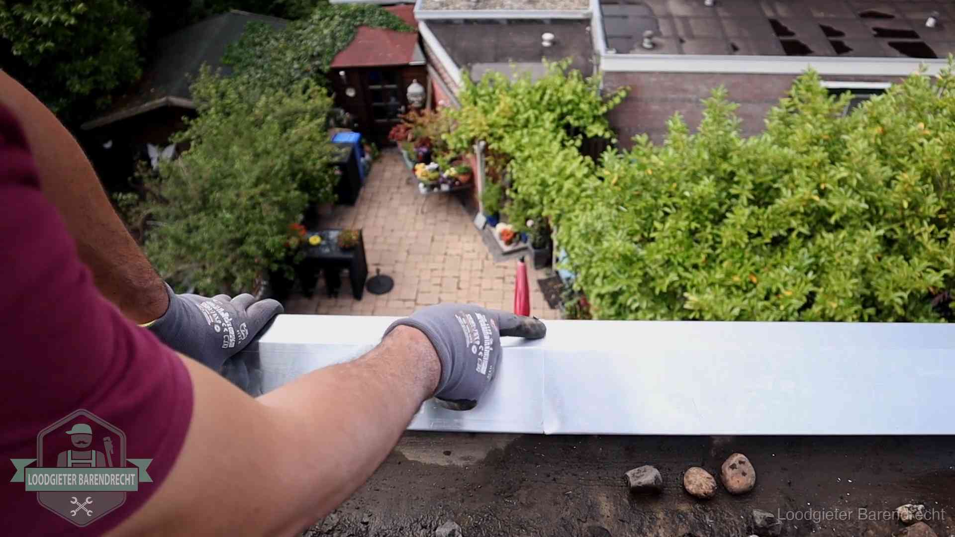 Daklekkage geregeld in Barendrecht Vakman plaatst een daktrim op de dakrand van een woning in Barendrecht