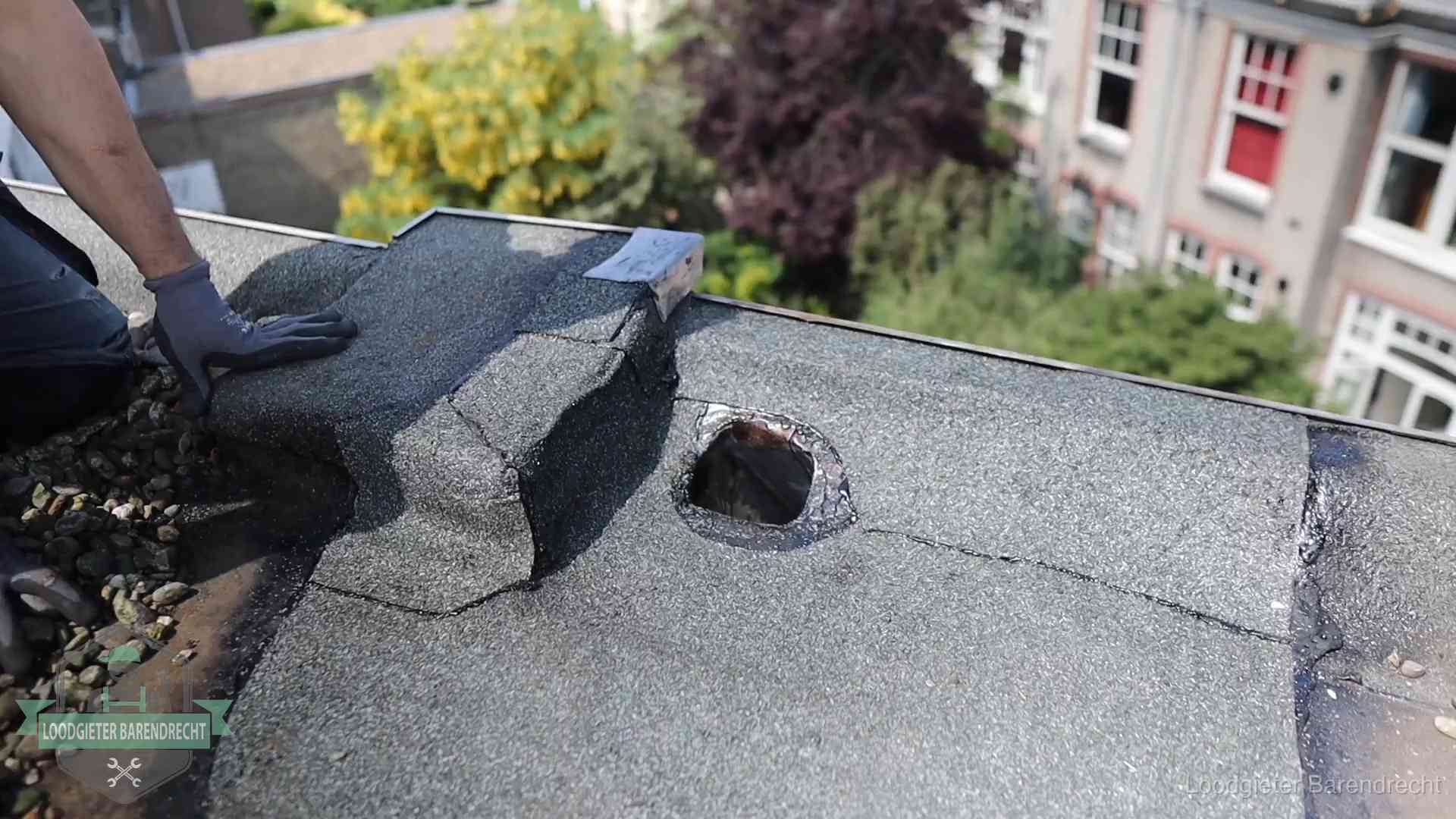 Daklekkage-inspectie op een plat dak in Barendrecht Loodgieter inspecteert een beschadigd bitumen plat dak tijdens een daklekkage-inspectie in Barendrecht