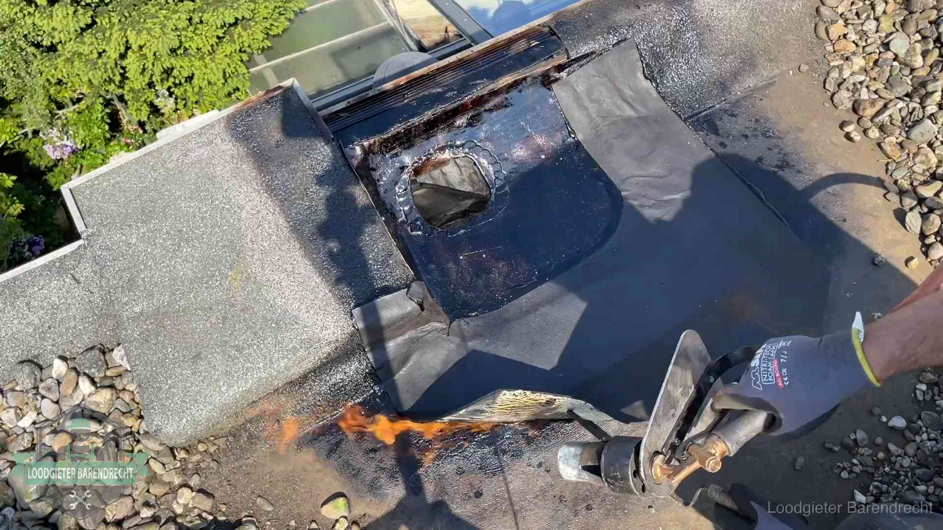 Daklekkage repareren in Barendrecht Dakdekker brandt bitumen rond een doorvoer tijdens een daklekkage-reparatie in Barendrecht