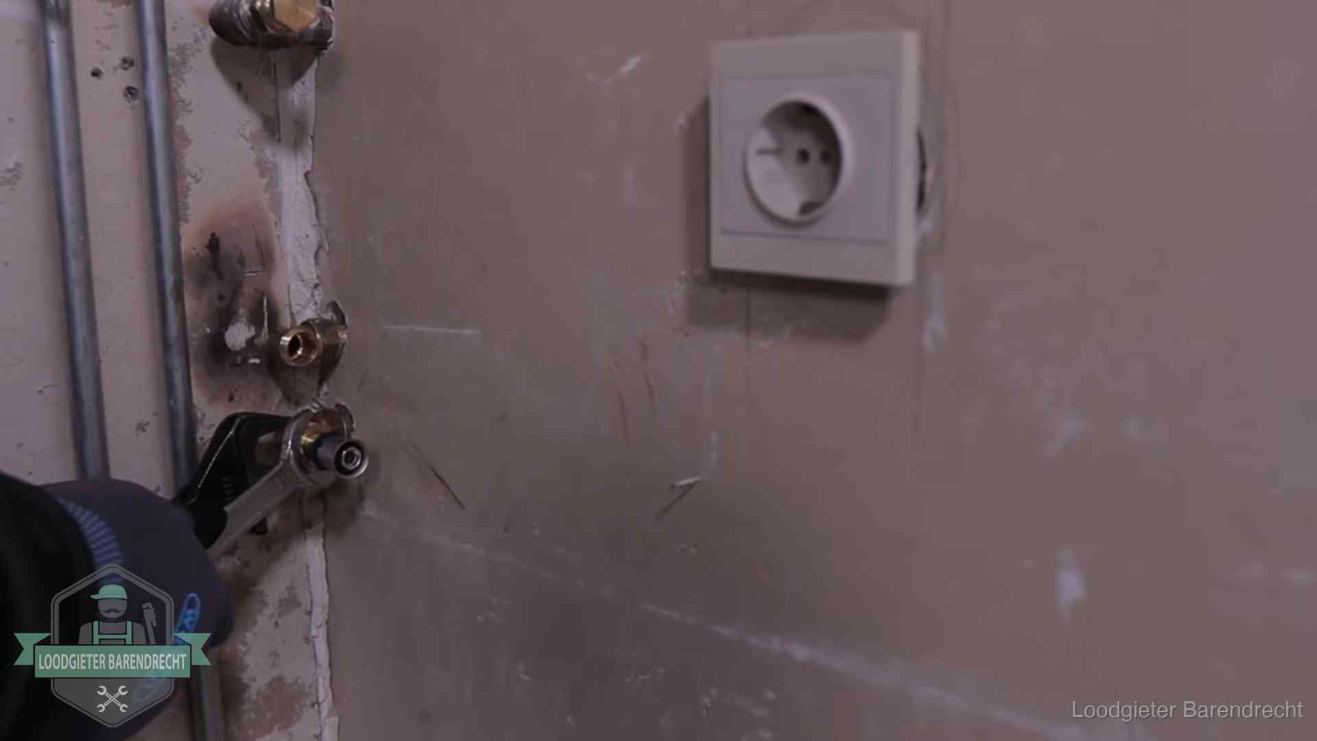 Monteur draait een perskoppeling vast op een leidingaansluiting in Barendrecht