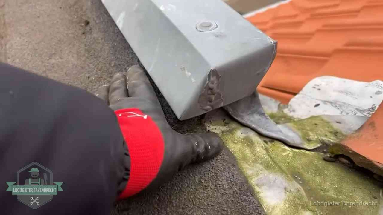 Hemelwaterafvoer en dakgoot controleren in Barendrecht Controle van een zinken hemelwaterafvoer met loodslab bij dakpannen in Barendrecht