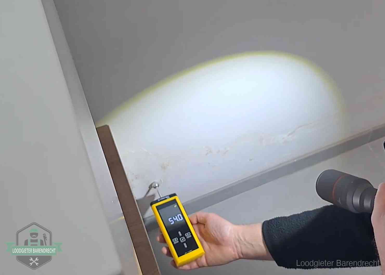 Vochtmeter tegen een natte wand met lekkagesporen in Barendrecht