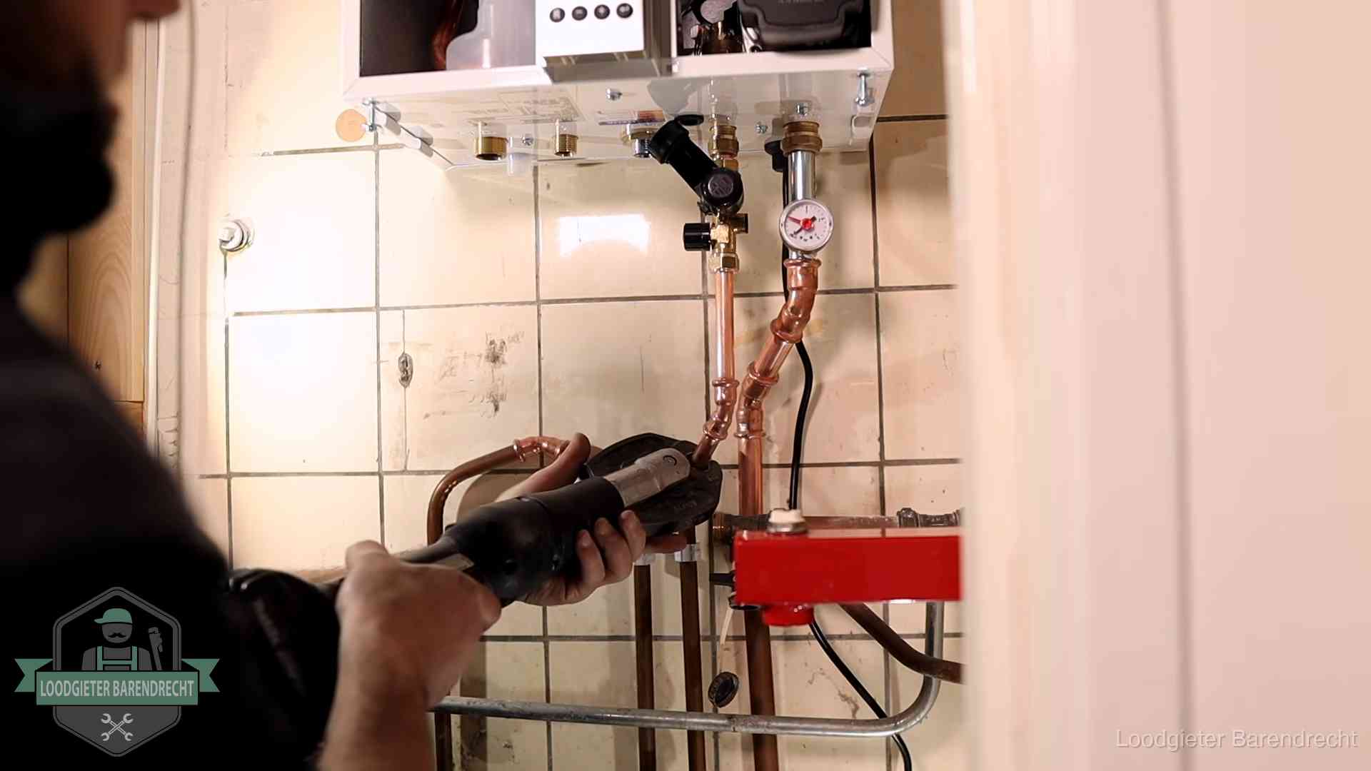 Monteur werkt aan de leidingen onder een cv-ketel in Barendrecht