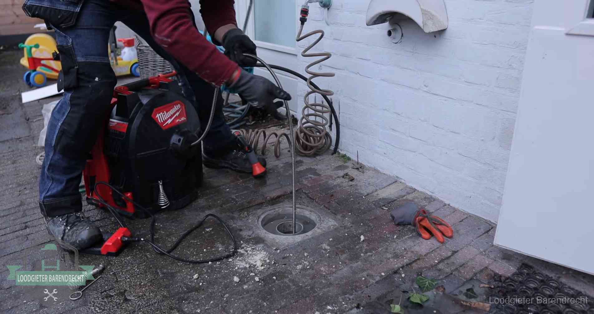 Erfgrens en gemeenteriool in Barendrecht Ontstoppingsputje in de bestrating naast de gevel van een woning in Barendrecht