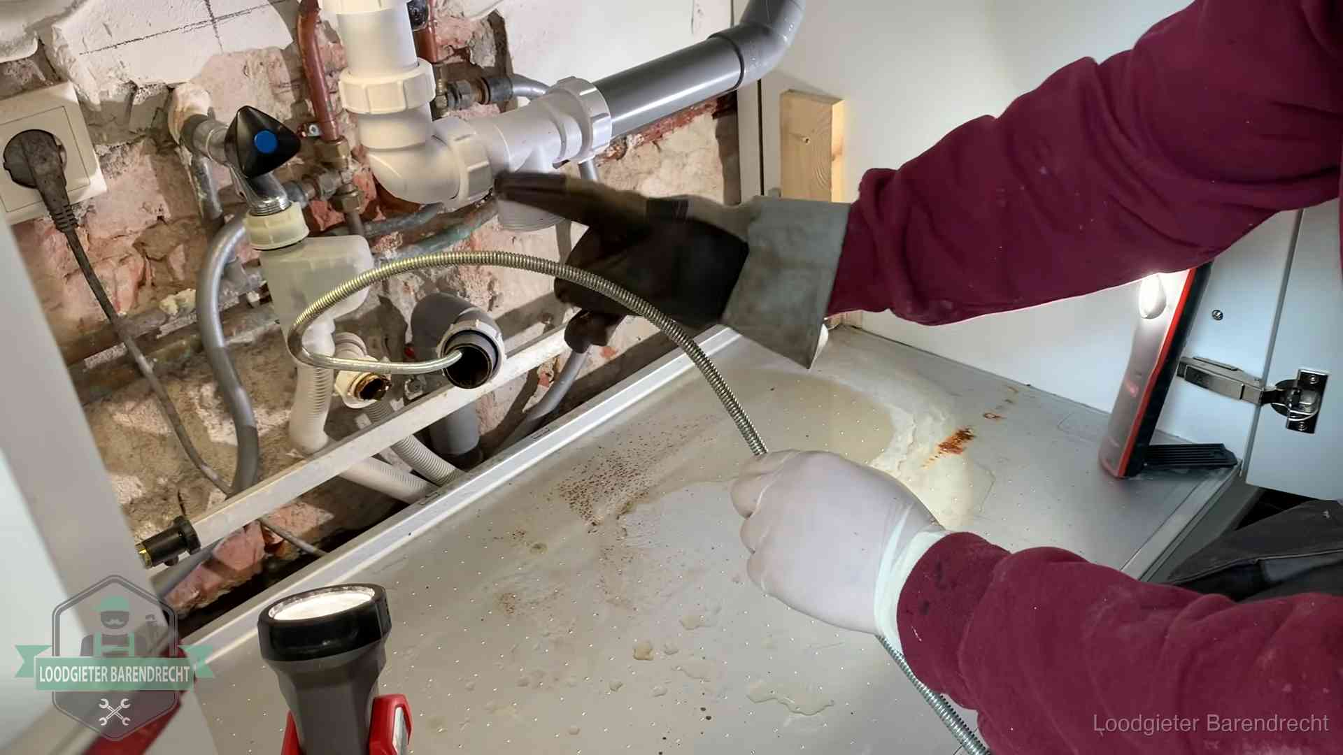 Spiraal of hogedruk in Barendrecht Ontstoppingsveer gaat in een geopende sifonaansluiting onder het aanrecht in Barendrecht