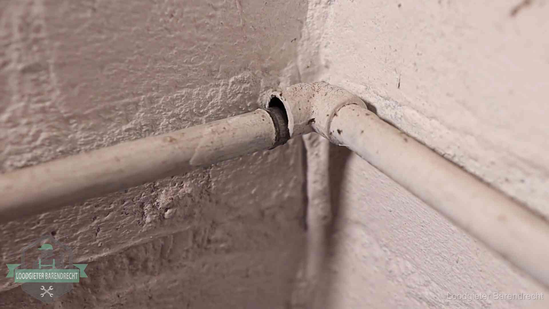 Oude geverfde waterleiding met een losliggende fitting in een woning in Barendrecht