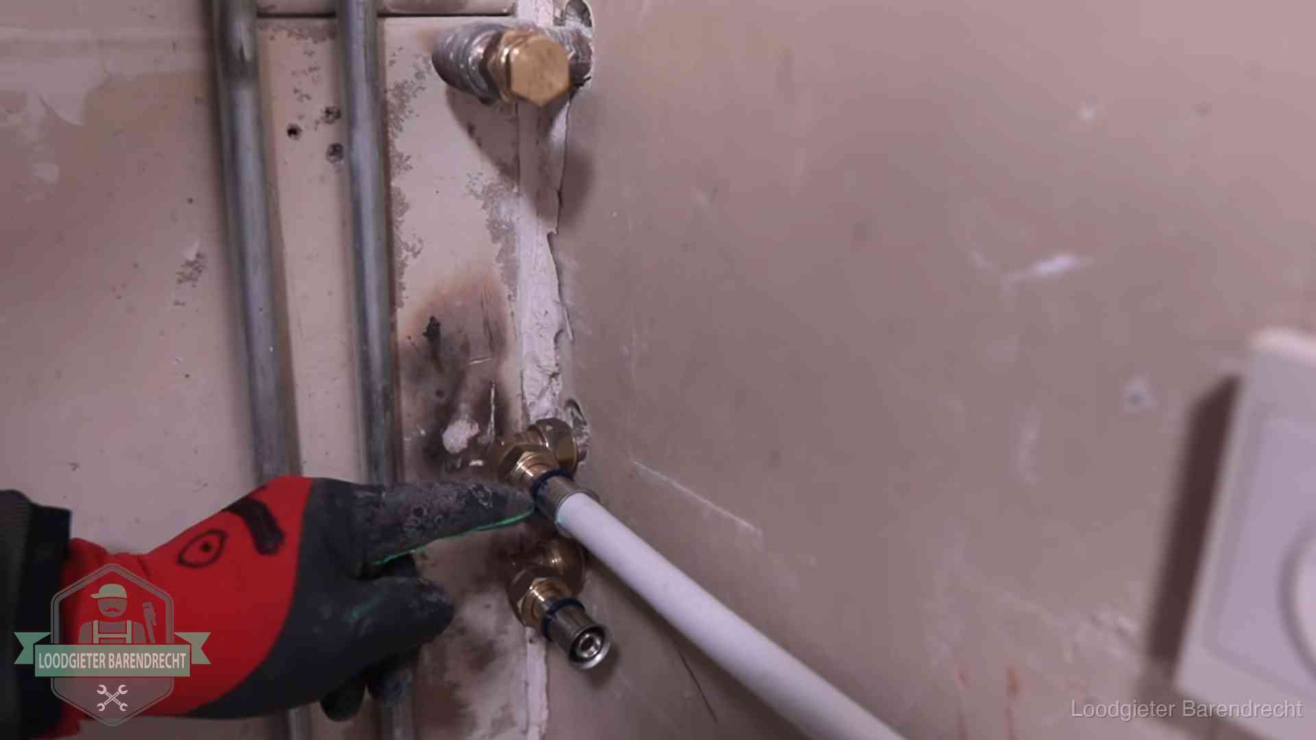 Loodgieter wijst de persfitting op nieuwe muuraansluitingen aan in een woning in Barendrecht