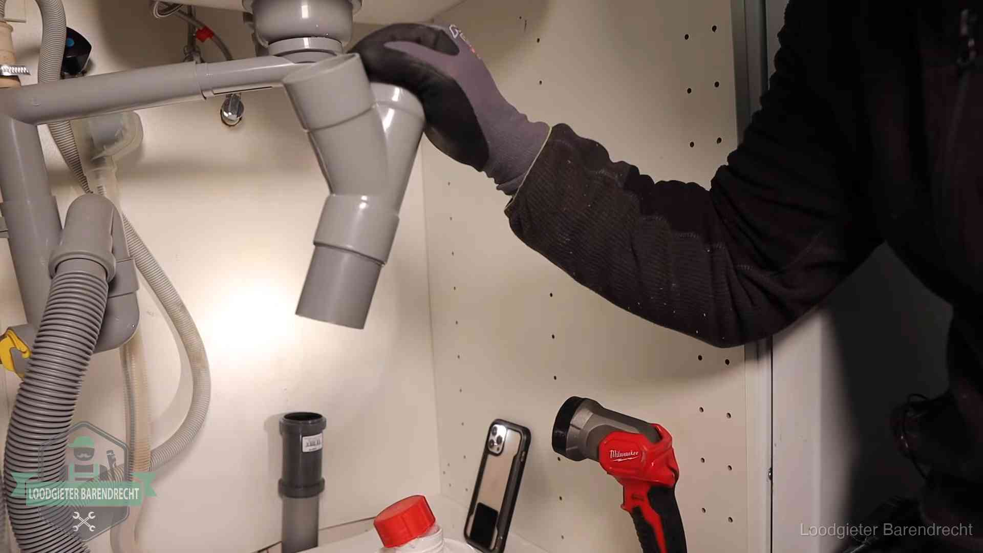 Rioollucht in huis verhelpen in Barendrecht Loodgieter demonteert het sifon- en afvoerwerk onder een gootsteen in Barendrecht bij stankklachten
