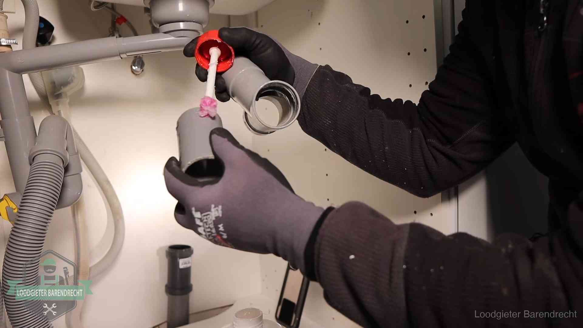 Oorzaak van een verstopte afvoer in Barendrecht Loodgieter demonteert en reinigt de sifon onder een keukenkast in Barendrecht