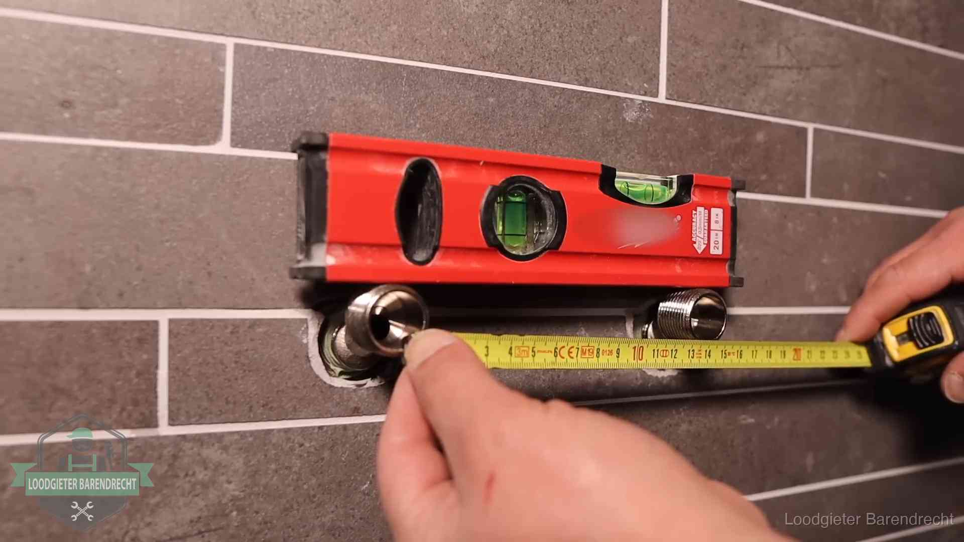 Waterpas en duimstok bij kraan-aansluitpunten in een badkamer in Barendrecht