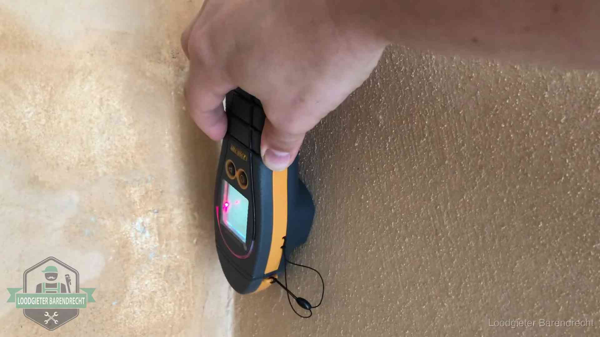 Daklekkage opsporen zonder hakwerk in Barendrecht Vochtmeter tegen een muur met vochtplekken tijdens het opsporen van een daklekkage in Barendrecht