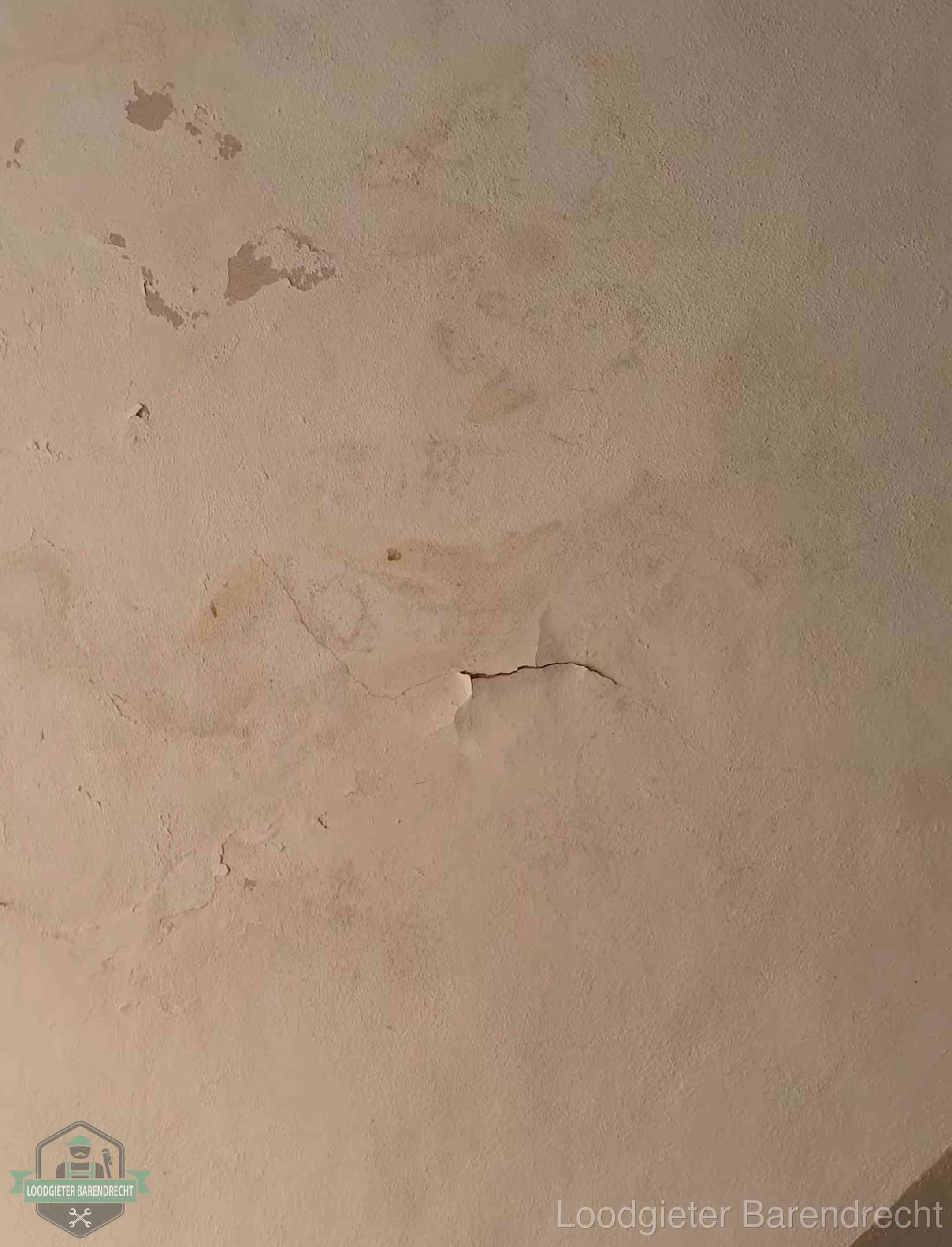 Vochtkringen en afbladderende verf op een plafond in Barendrecht, schade voor het meetrapport en de verzekering